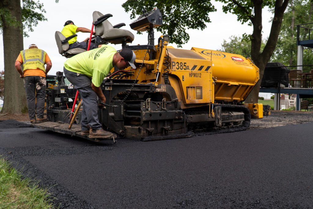 Dunn Company team paving asphalt driveway at a residential home.